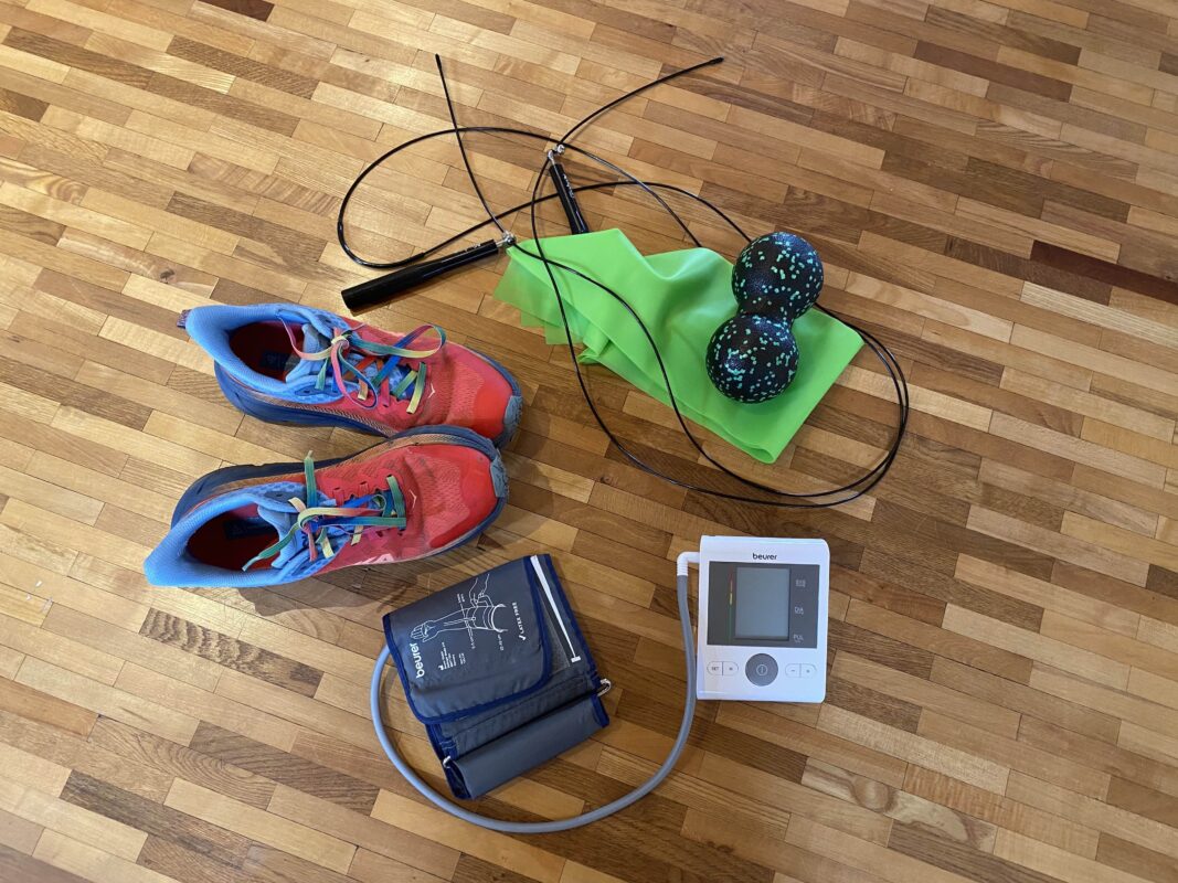 Blutdruckmessgerät mit Turnschuhen und Trainingsutensilien – Training bei Bluthochdruck