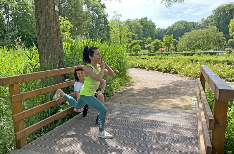 Personal Trainerin in Frankfurt begleitet funktionelles Freilufttraining mit Bulgarian Split Squat zur Förderung von Kraft, Stabilität und Beweglichkeit