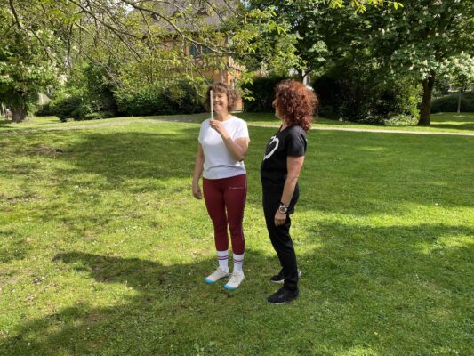 Personal Trainerin erklärt Kundin den Augenliegestütz im Neuroathletiktraining in Frankfurt.