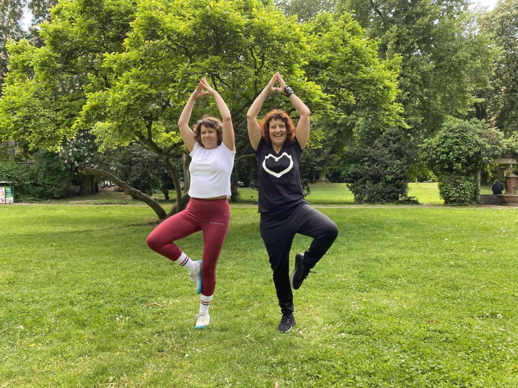 Personal Trainerin Marion Kinzig übt mit einer Kundin beim Sturzprophylaxetraining die Yoga-Übung ‚Der Baum‘ – gezieltes Gleichgewichtstraining für mehr Stabilität und Sicherheit.