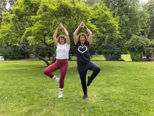Personal Trainerin Marion Kinzig übt mit einer Kundin beim Sturzprophylaxetraining die Yoga-Übung ‚Der Baum‘ – gezieltes Gleichgewichtstraining für mehr Stabilität und Sicherheit.